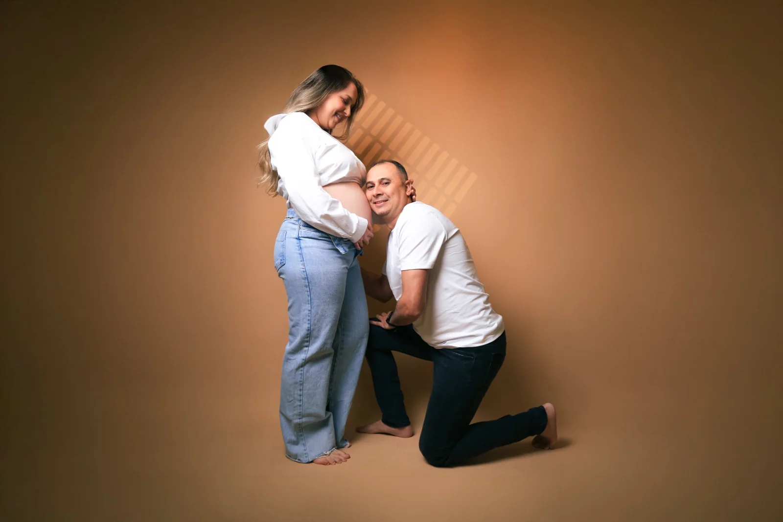 Wellington ajoelhado encostando o rosto na barriga de Deborah