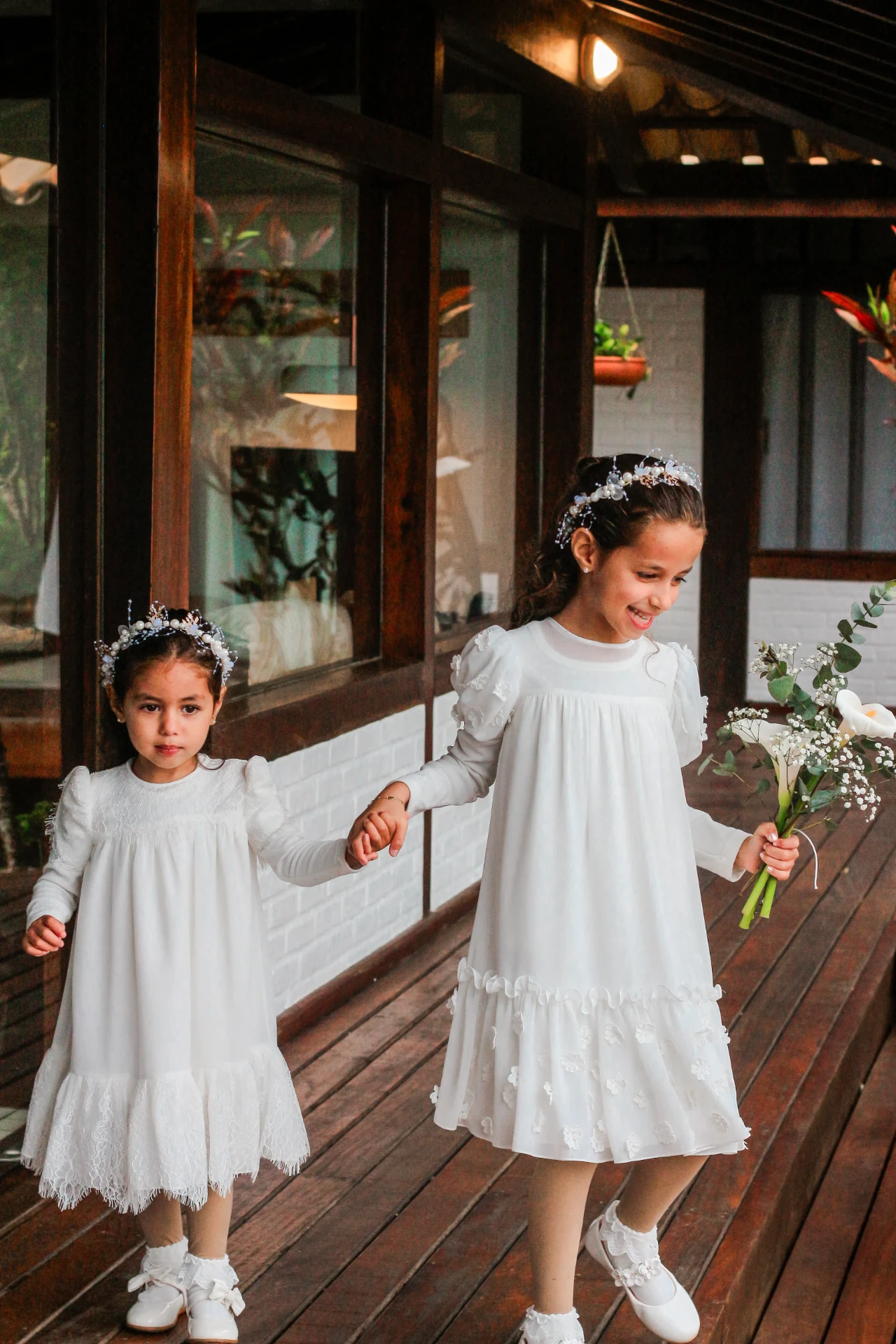 Larissa e Roberto — Daminhas de mãos dadas caminhando pelo deck de madeira