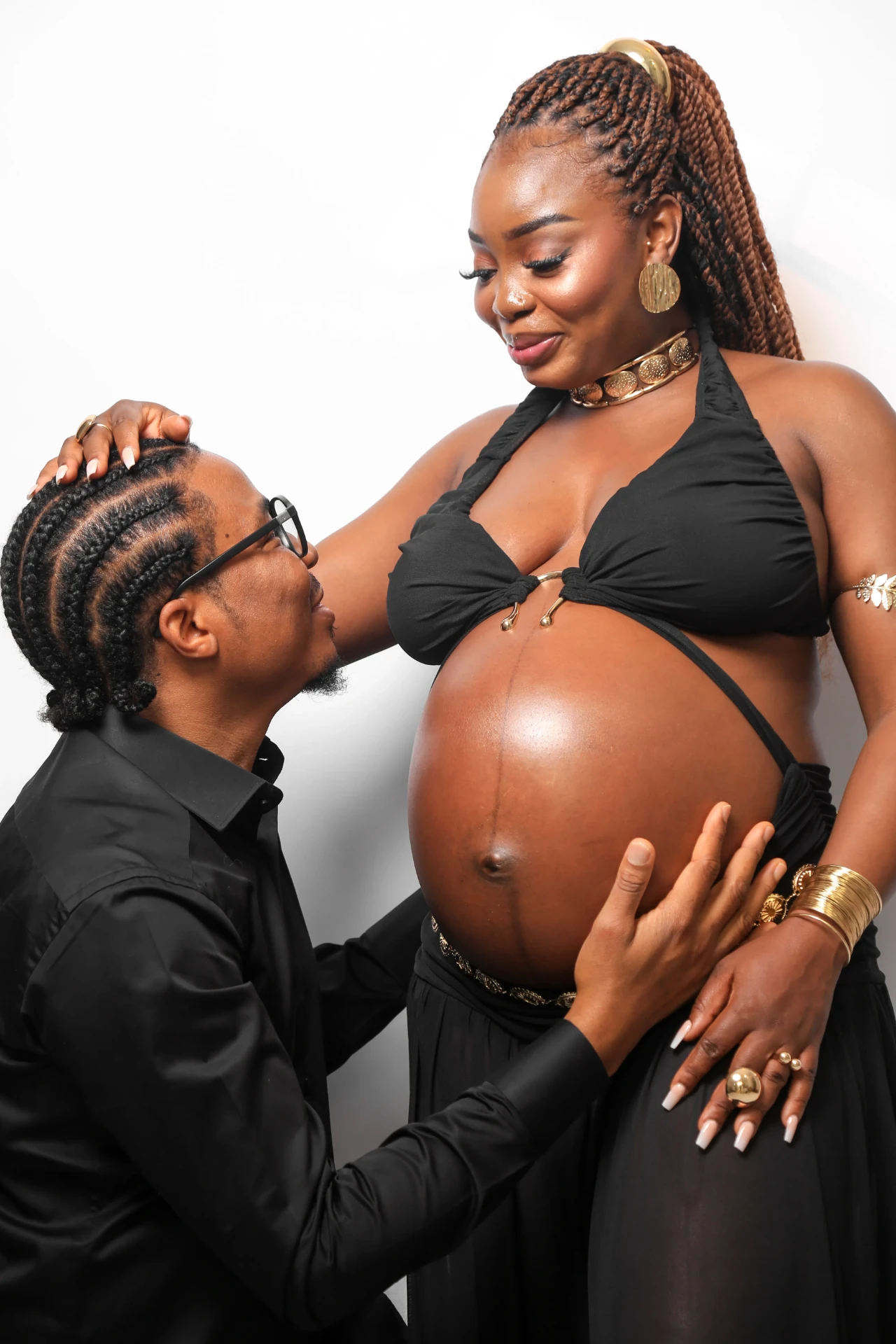 Casal se olhando com a mão na barriga da gestante