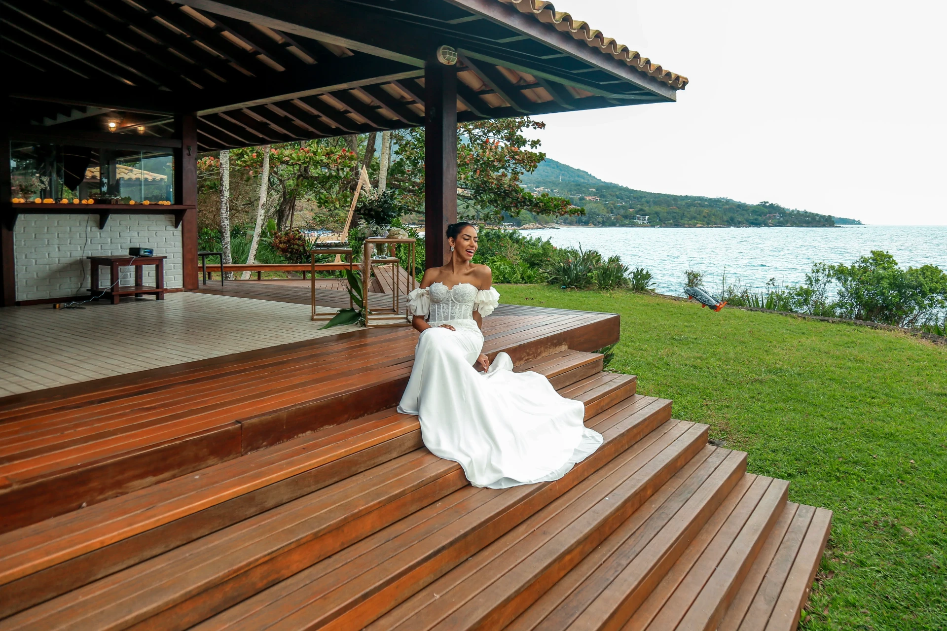 Larissa e Roberto — noiva no deck do quiosque com vista para a praia