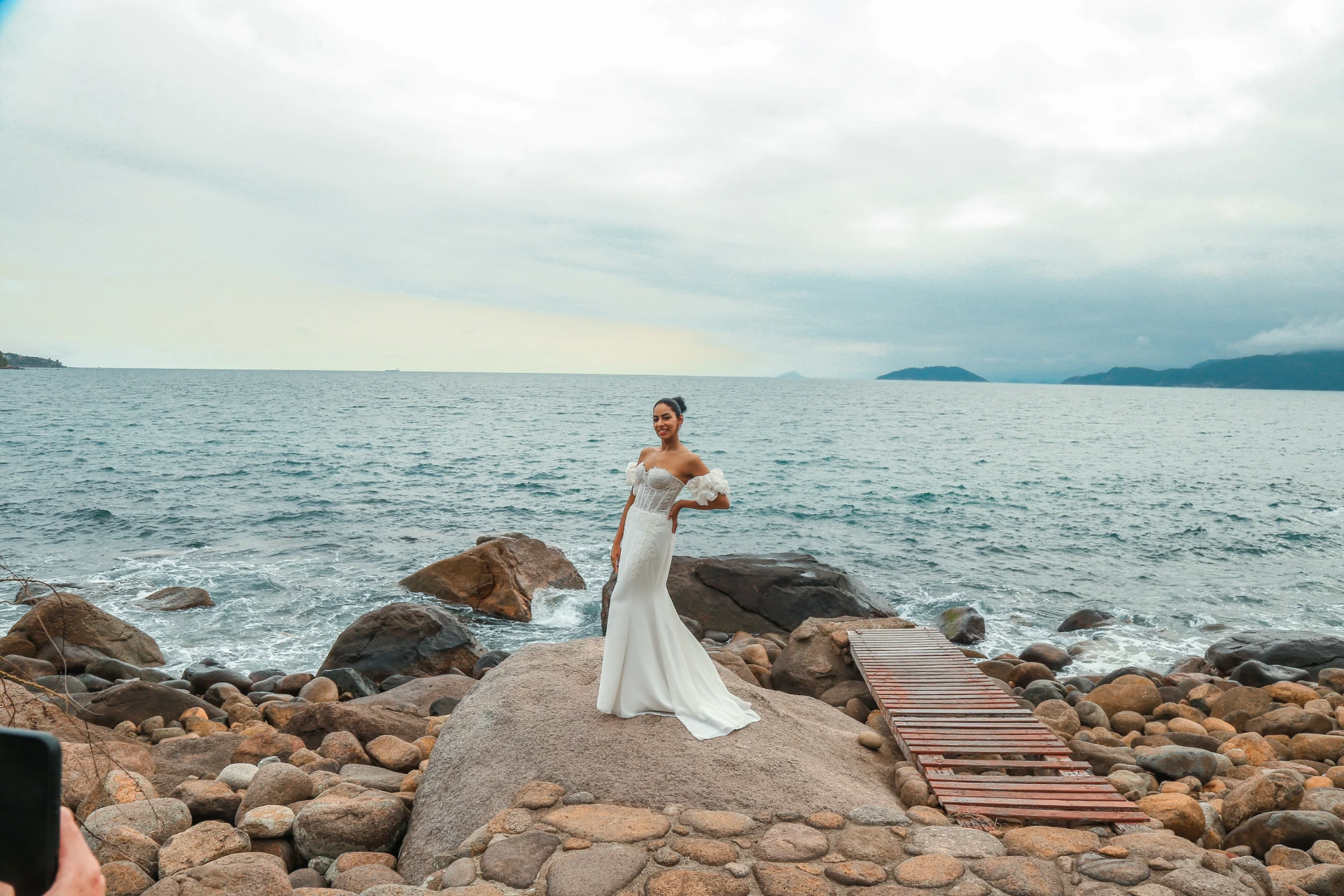Larissa e Roberto — noiva sobre a pedra com o mar aberto ao fundo
