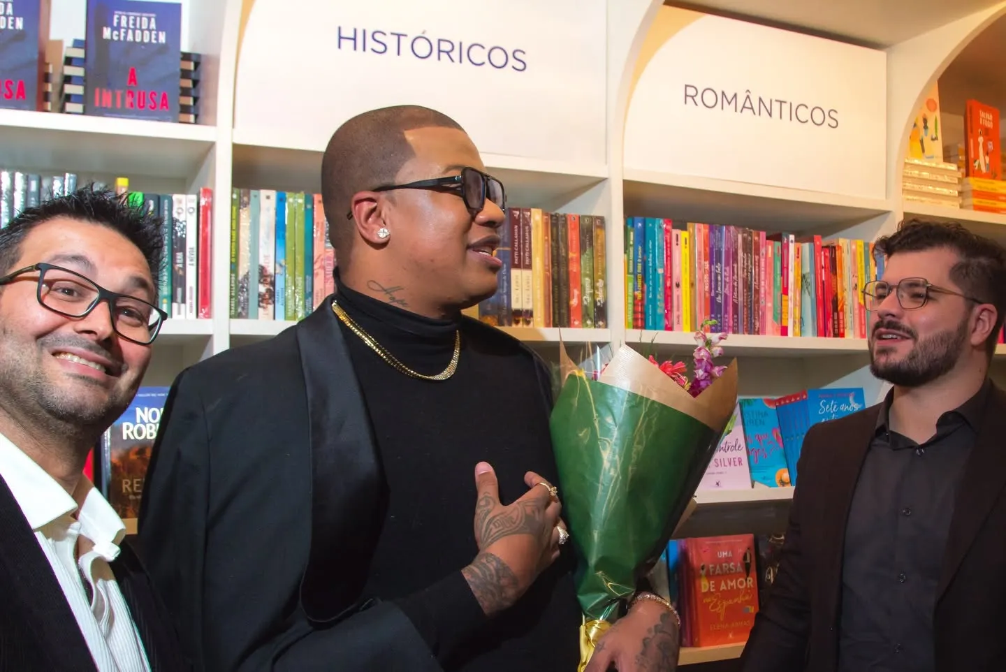 Lançamento do livro O Preço da Alma — autor com buquê de flores ao lado de convidados