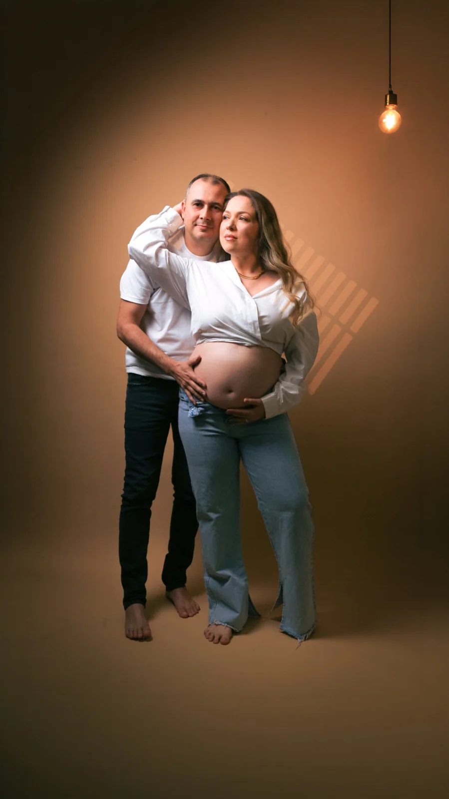 Deborah e Wellington de pé com as mãos sobre a barriga