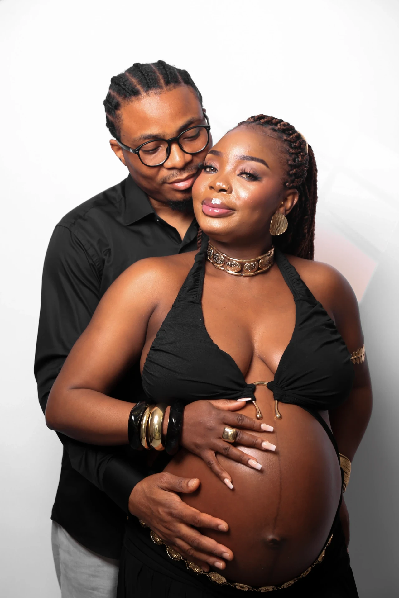 Casal abraçado com as mãos sobre a barriga da gestante