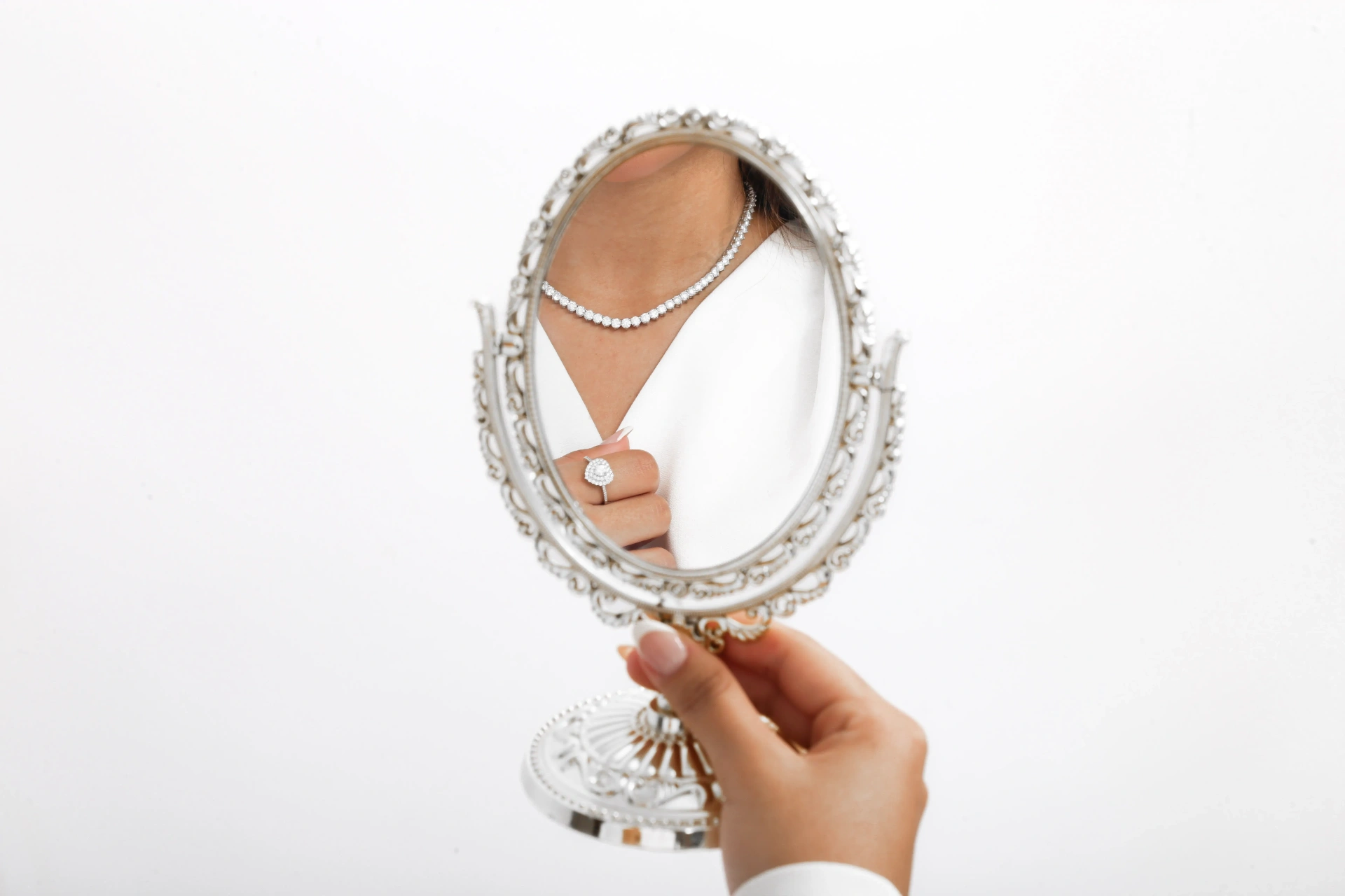 Fina Jolie reflexo em espelho ornamentado com colar e anel