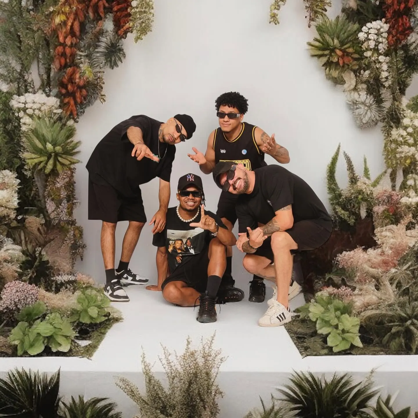 Grupo Lied — quatro integrantes posando em cenário de jardim com parede florida