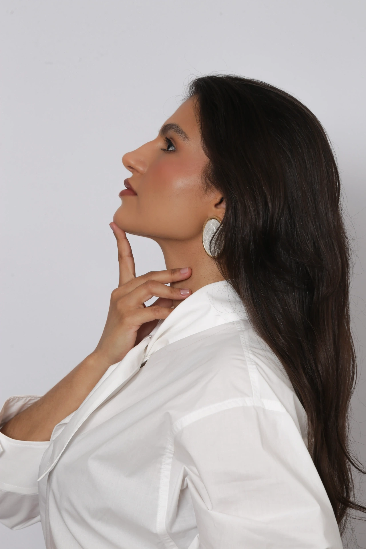 Amanda Siara de perfil com brinco dourado
