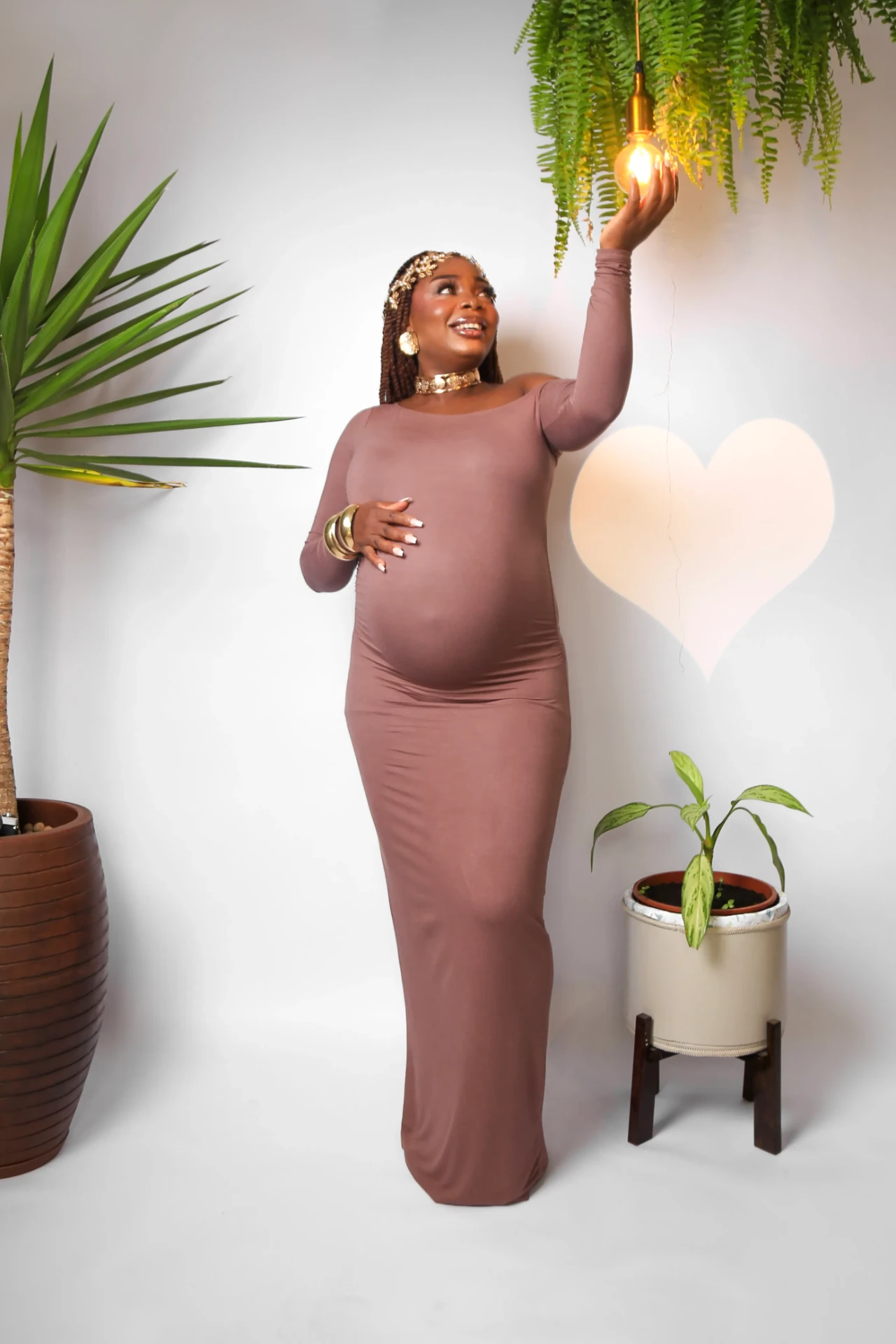 Gladys Ojonugwa gestante tocando lâmpada em estúdio