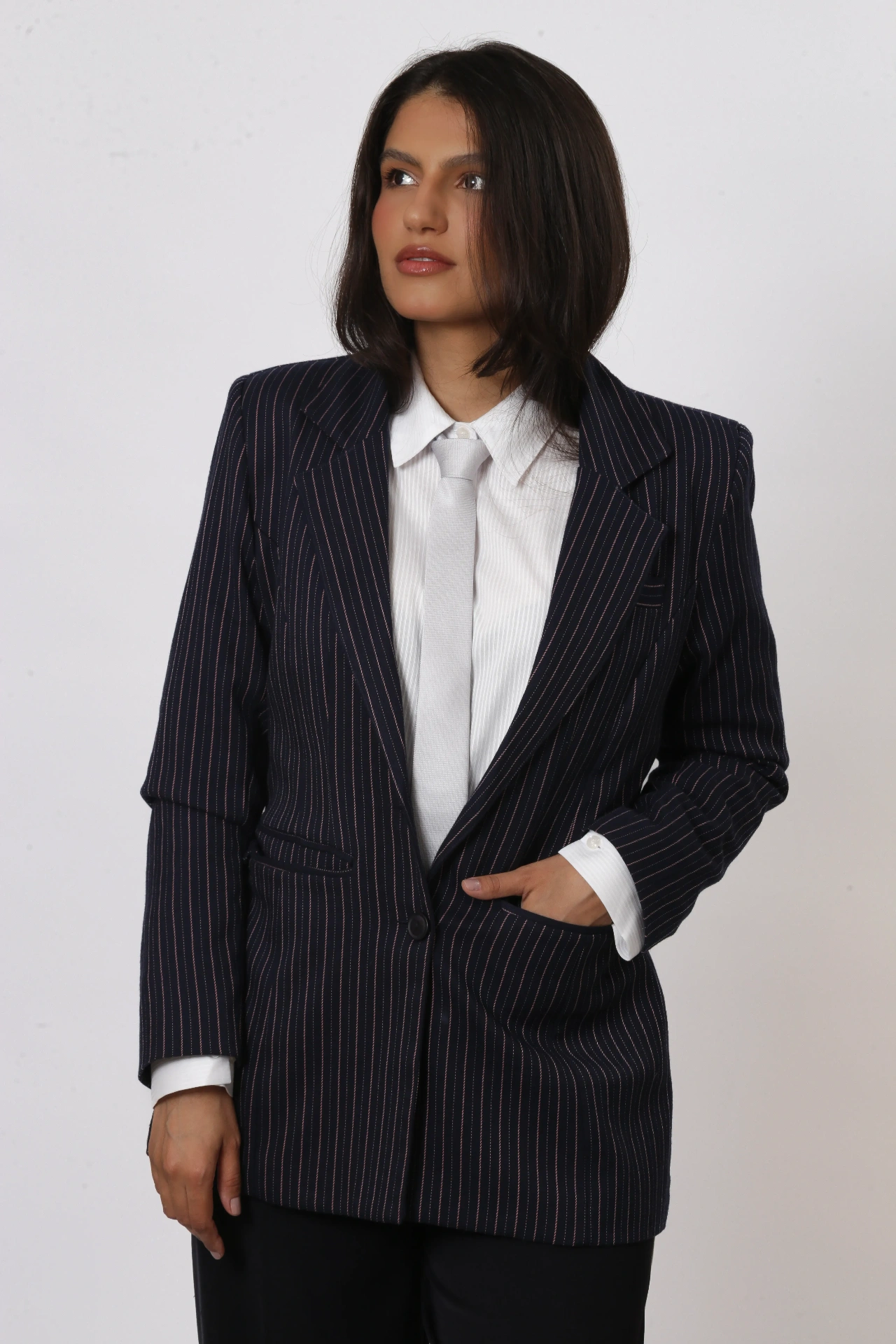 Amanda Siara com blazer risca de giz azul marinho e gravata branca