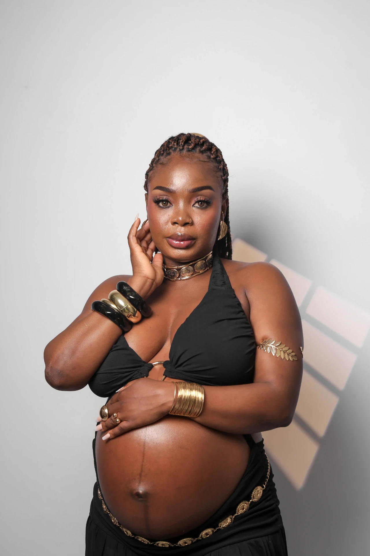 Retrato de Gladys Ojonugwa gestante com braceletes dourados
