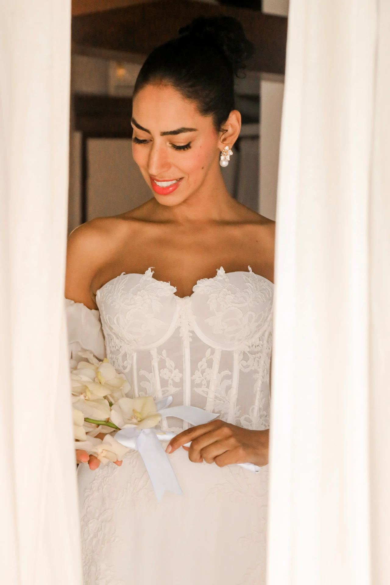 Larissa e Roberto — detalhe do vestido de renda com o buquê de orquídeas