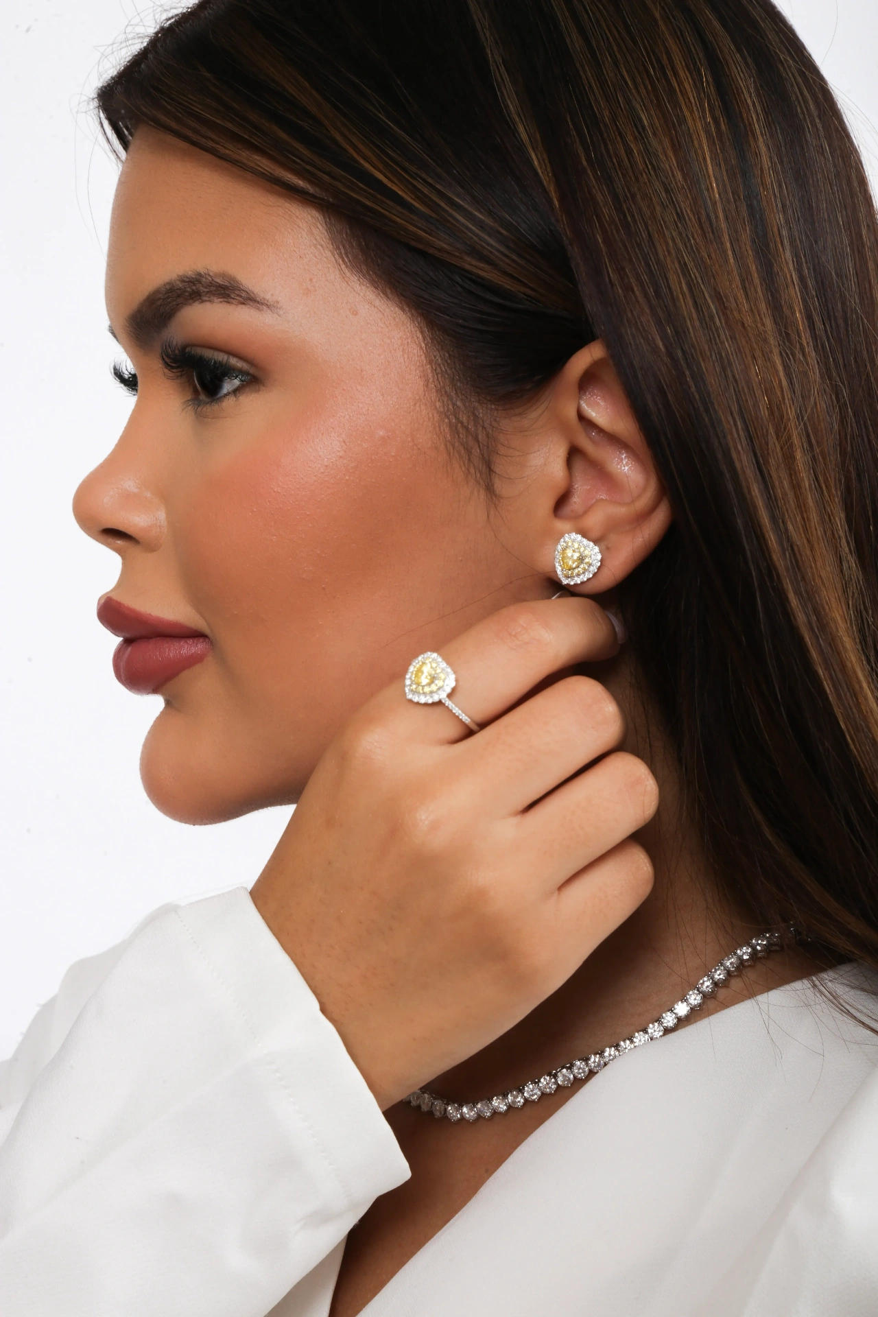 Fina Jolie perfil com brinco, anel e colar de diamante amarelo