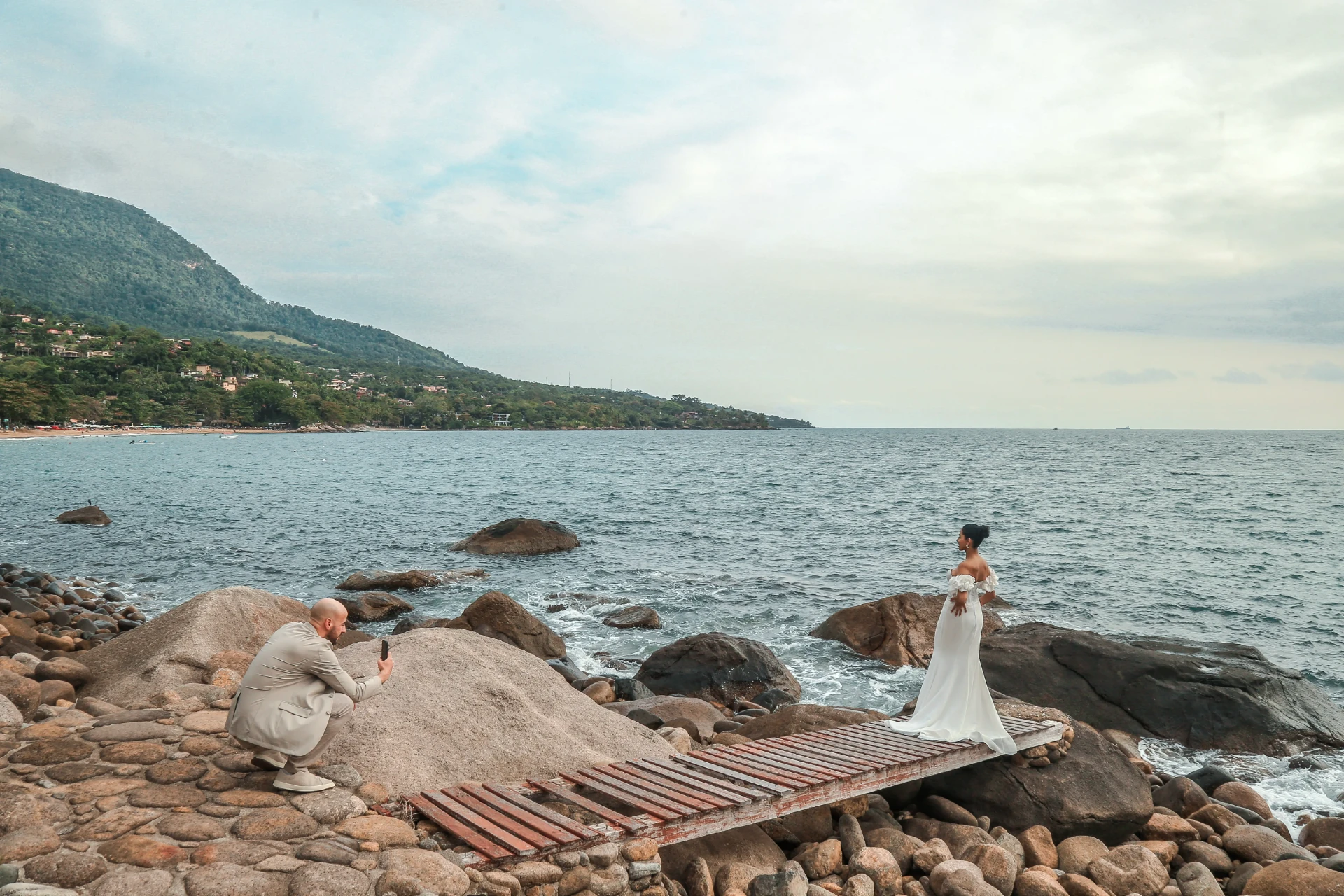 Larissa e Roberto — noivo fotografando a noiva na costa rochosa