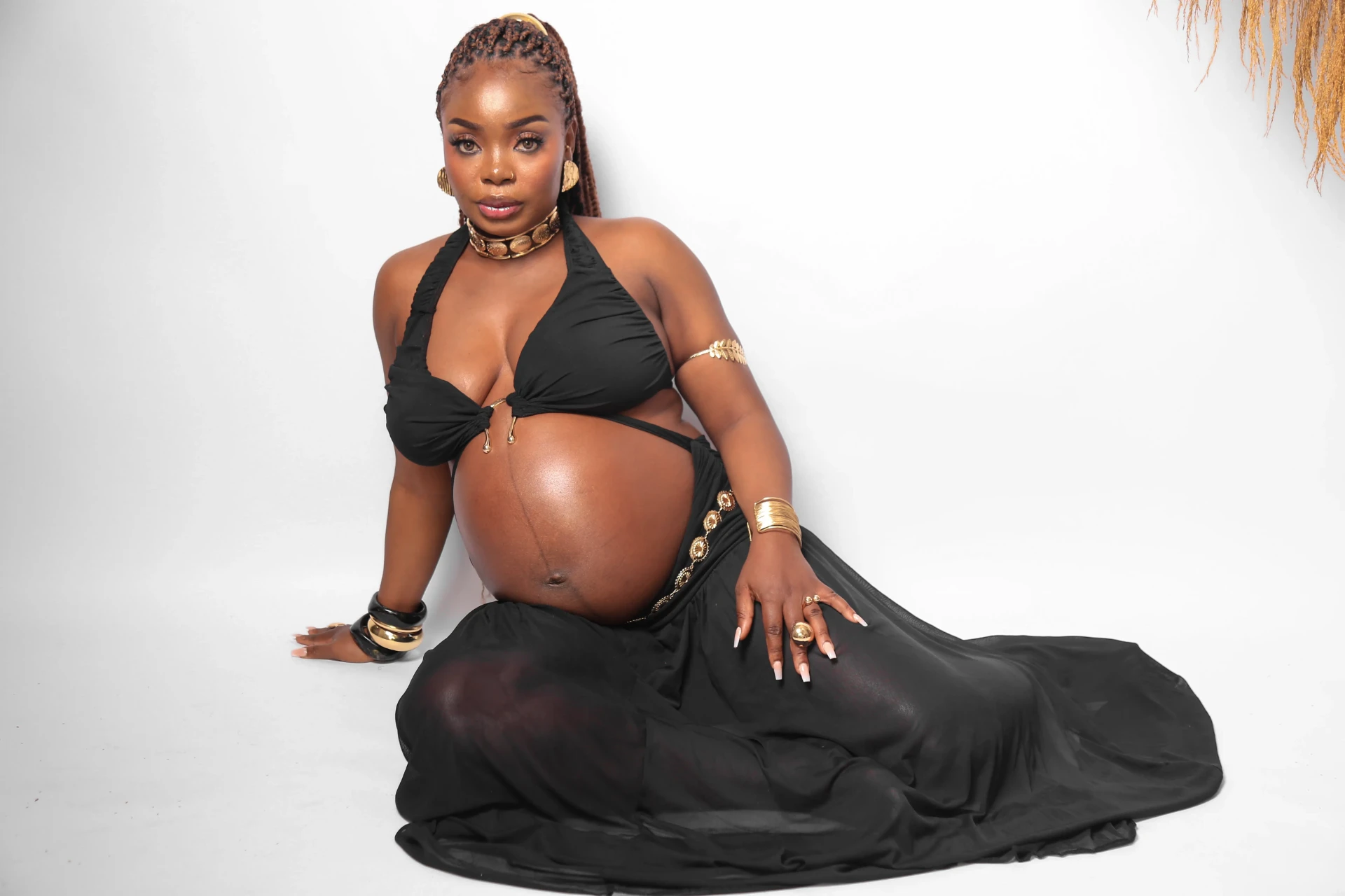 Gladys Ojonugwa gestante sentada em fundo branco