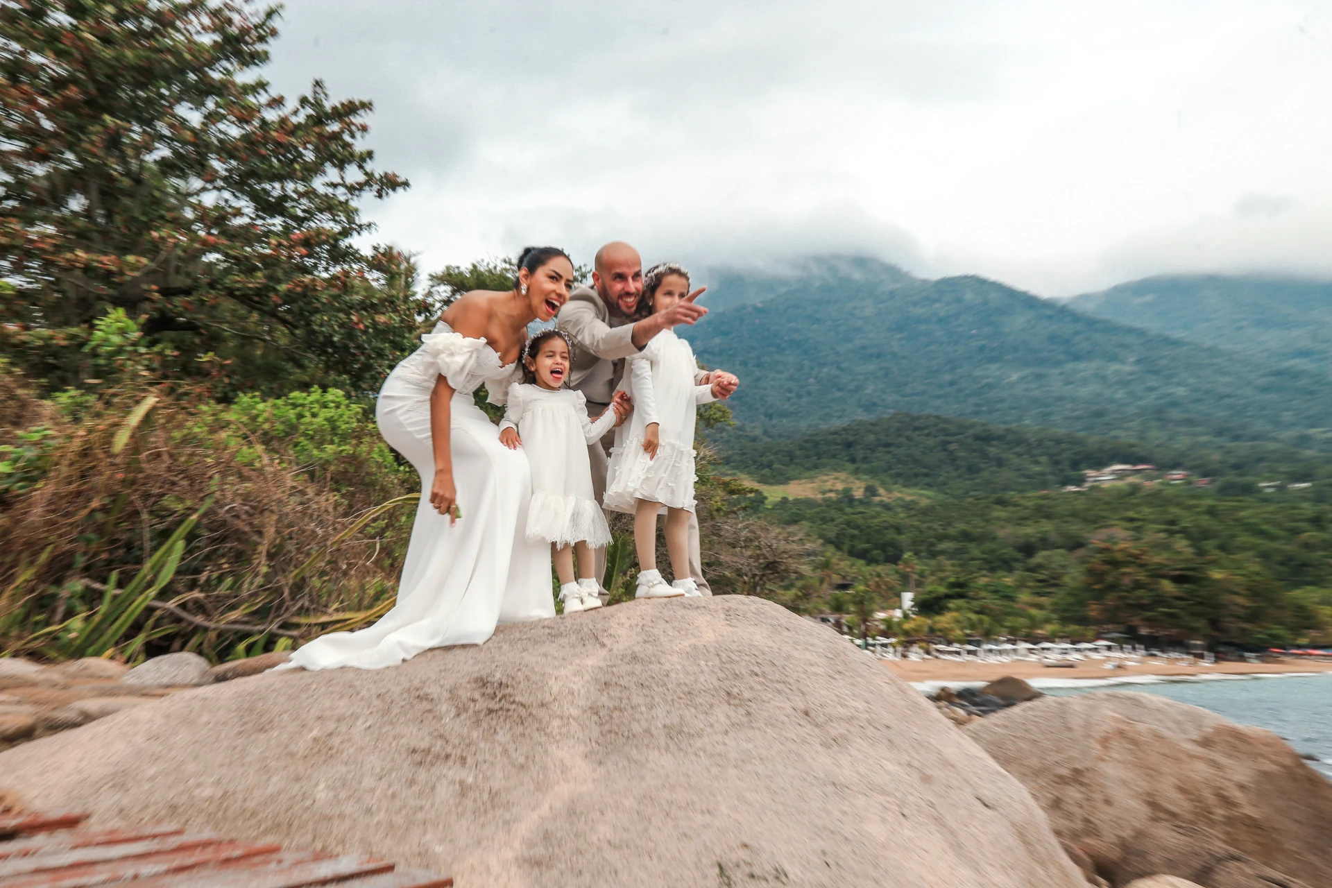 Larissa e Roberto — momento divertido da família sobre a pedra com a montanha ao fundo