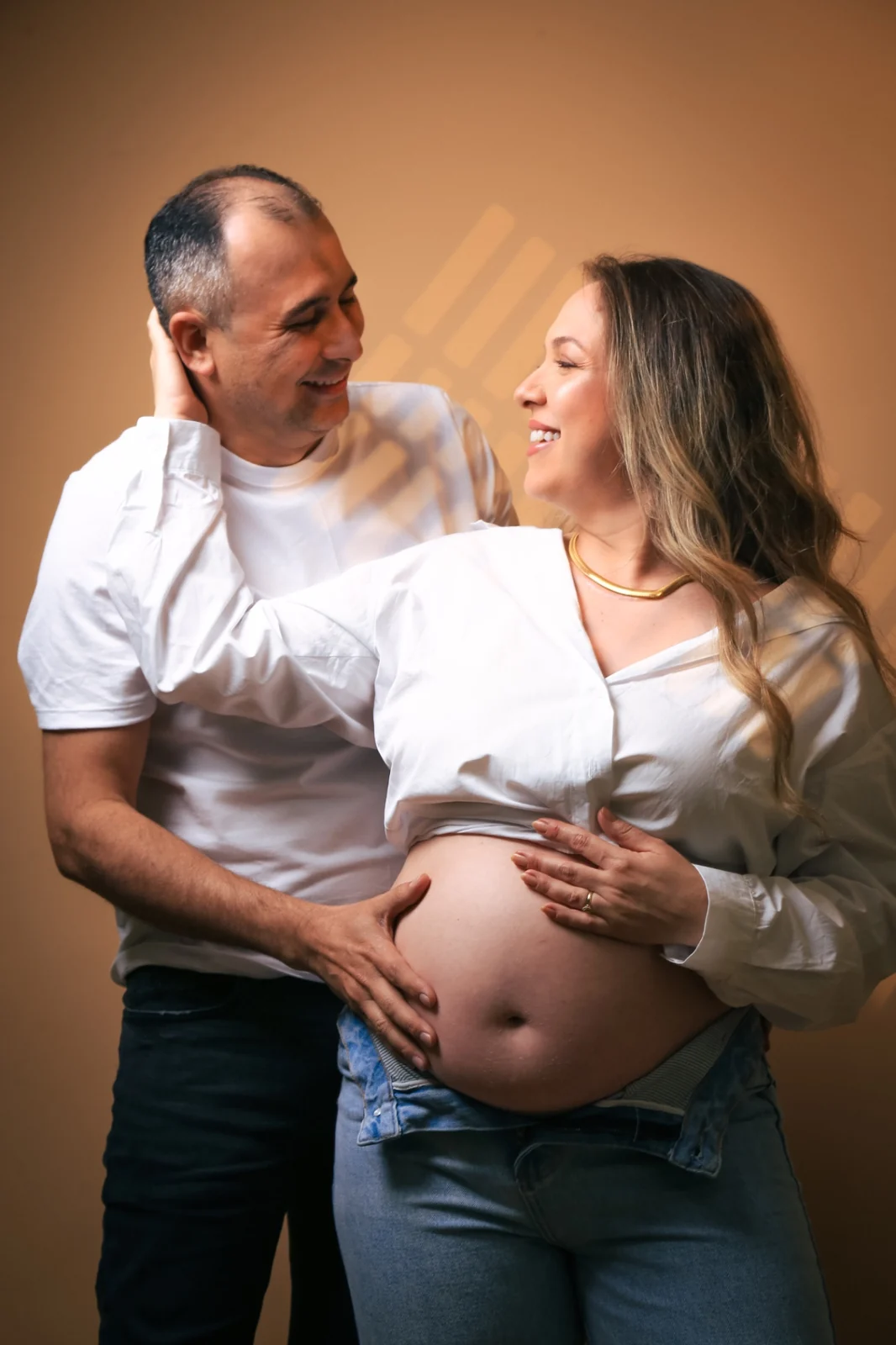 Deborah e Wellington sorrindo um para o outro em estúdio