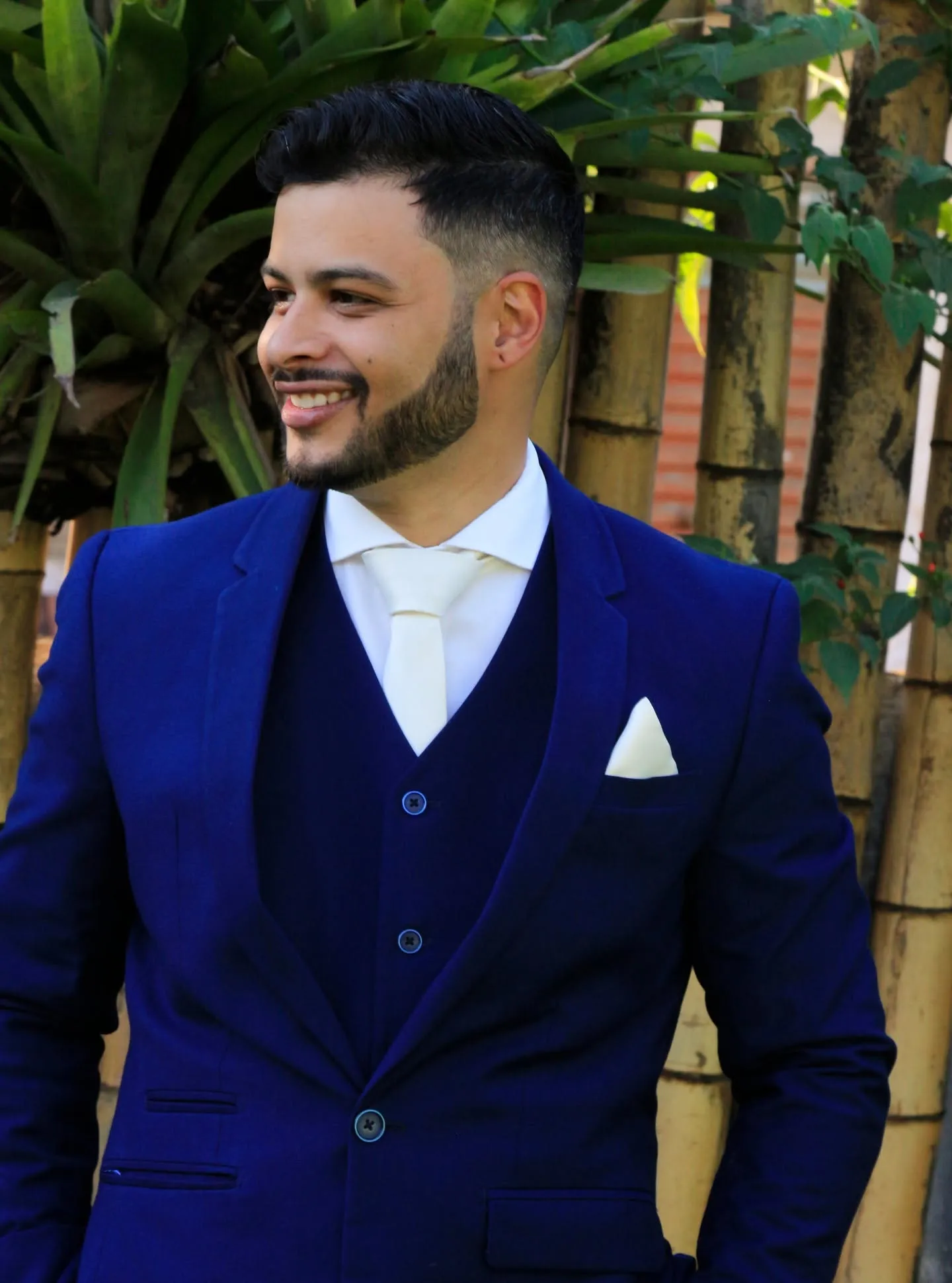 Lucas — noivo em terno azul royal sorrindo no jardim