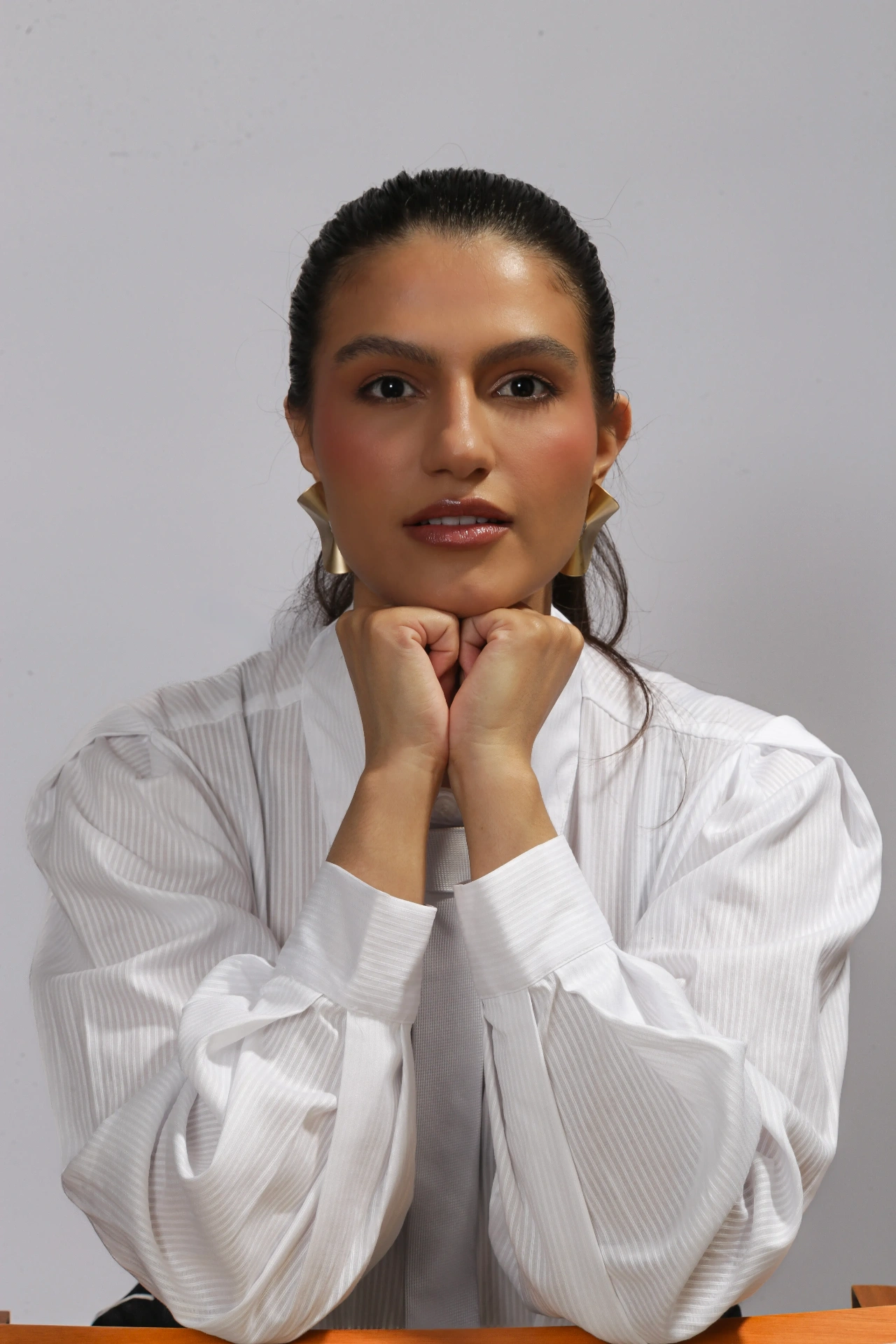 Amanda Siara apoiando o queixo nas mãos em retrato editorial