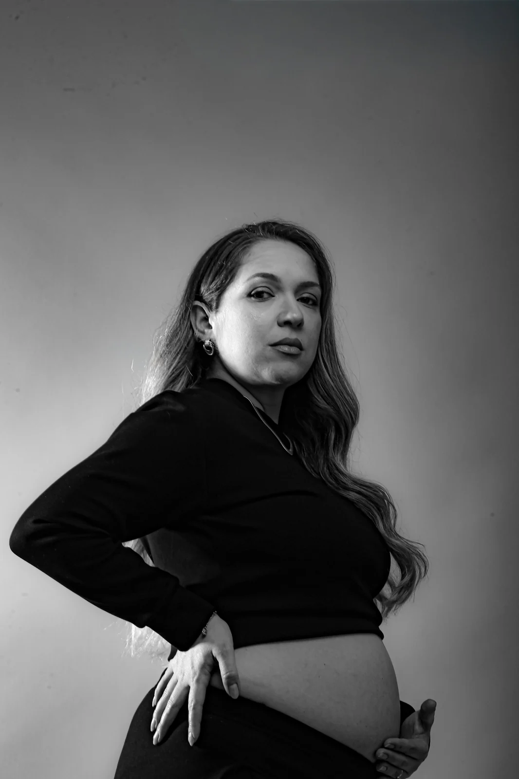 Deborah gestante de roupa preta em retrato preto e branco