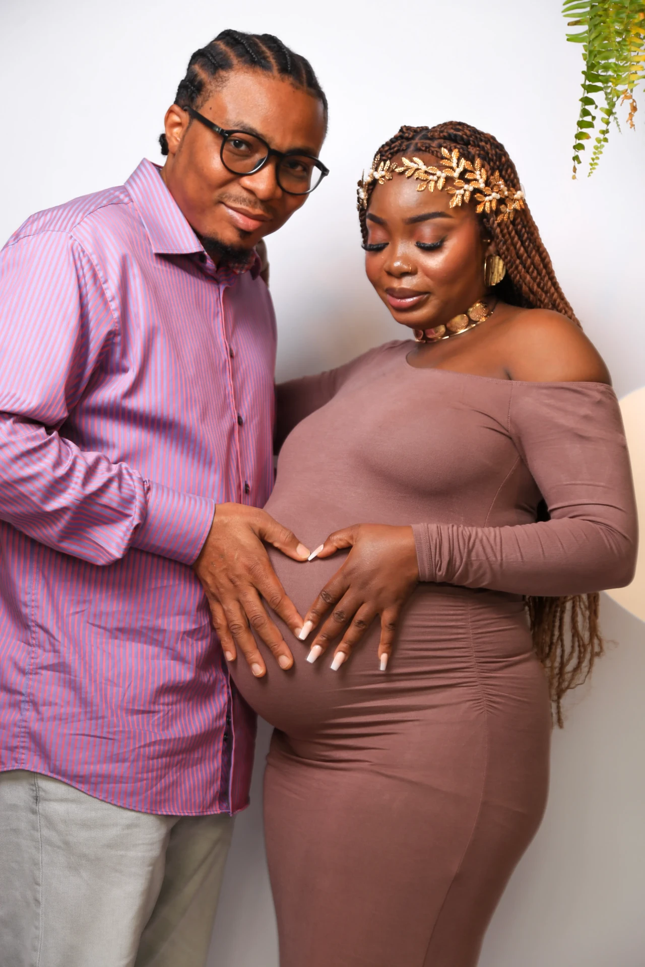 Casal formando coração com as mãos na barriga