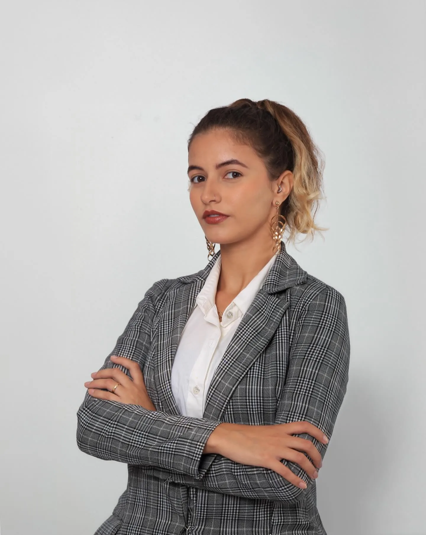 Leticia Hollup de braços cruzados em estúdio
