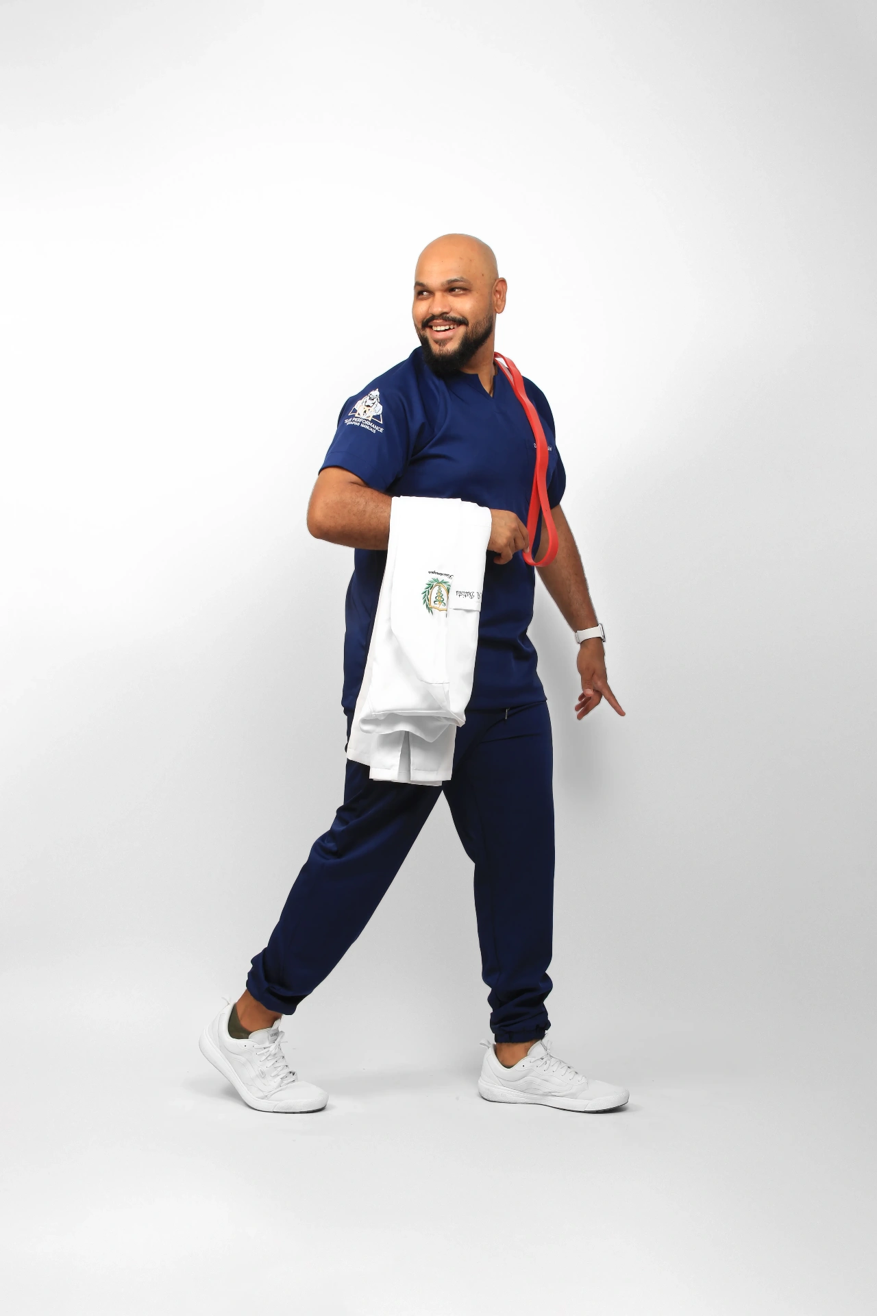 Dege Batista de corpo inteiro com jaleco no braço