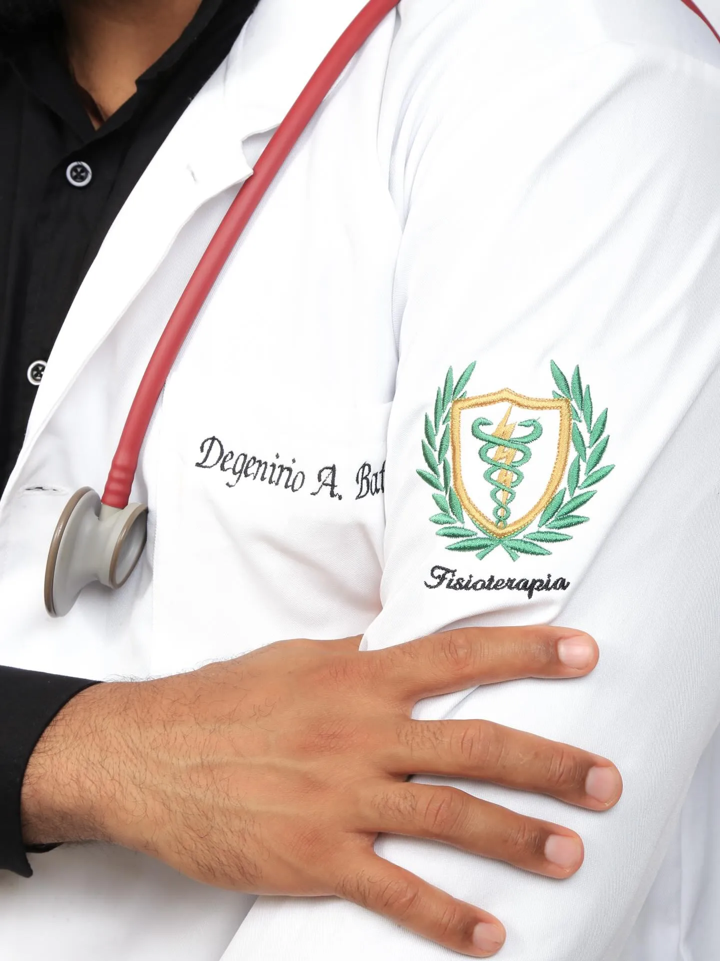 Detalhe da mão de Dege Batista no jaleco